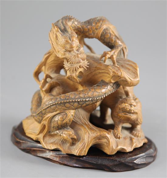 A Japanese boxwood okimono modelled as a dragon and a tiger, early 20th century, height 11cm, associated wood stand